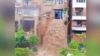 Flood water gushes through residential building in SW China creating a waterfall