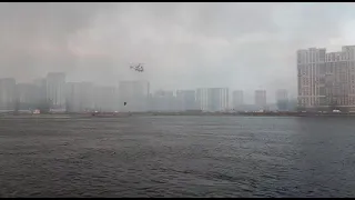 Вертолет набирает воду из Невы для тушения пожара на "Невской мануфактуре", Петербург, 12.04.2021