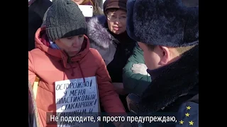 Женщина с табличкой "Осторожно! У меня пластиковый стаканчик!" и полицейский на марше Немцова