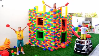 Vlad et Niki jouent avec des blocs de jouets colorés et construisent une maison à trois niveaux