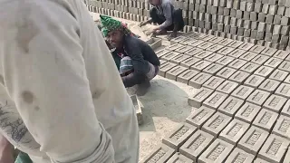 Bangladeshi village man making clay soil brick in a wood shaped box manually