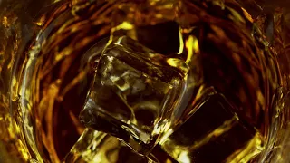 FREE STOCK VIDEO 4K | Slow Motion Macro Shot of Pouring Whiskey into Glass with Ice Cubes.