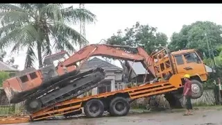 Sure, here's the process for loading and unloading a Hitachi excavator onto a self-loader truck