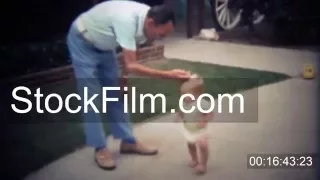 1979: Grandfather greets toddler playing in suburban front yard. DOWNEY, CALIFORNIA