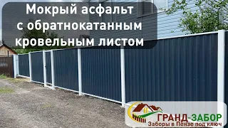 Забор из обратнокатанного кровельного листа цвета Мокрый асфальт с белым выносным каркасом.