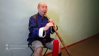 Му Юйчунь играет на бамбуковой флейте сяо китайскую мелодию