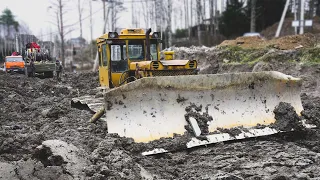 Бульдозер на болотных гусеницах залип в глине.