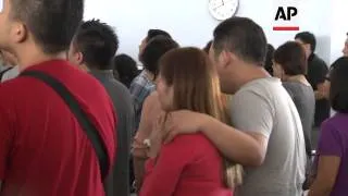 Relatives of passengers on missing AirAsia flight mourn and pray for victims