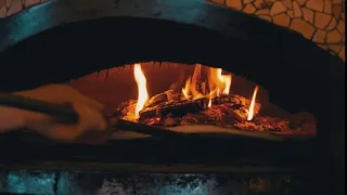 cooking pizza in an italian woodfired clay oven in 5RADUSW