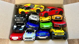 Box full of various miniature cars Peugeot, Volvo, Renault, Hyundai, Pagani, Cadillac One, DHL 31