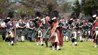 Massed Pipes & Drums parade to start the 2019 Dufftown Highland Games in Moray, Speyside, Scotland