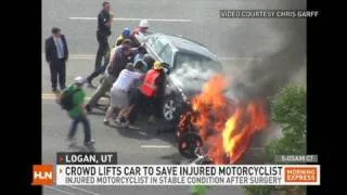 Crowd lifts burning car off man