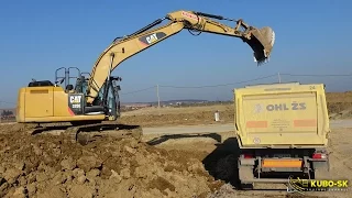 CAT 320E excavator loading trucks with clay dirt