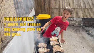 Russian boy cooking pork on the grill