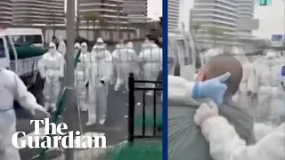 Police in hazmat suits scuffle with people in Shanghai