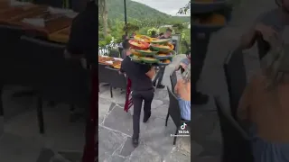 A waiter carries 15 plates to an outdoor party..smh