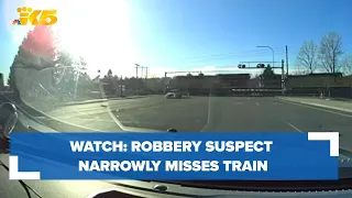 Dashcam video shows fleeing robbery suspect narrowly misses train