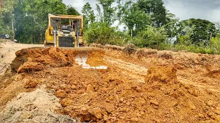 Awesome CAT D6R XL bulldozer working to widen the road on a steep hill