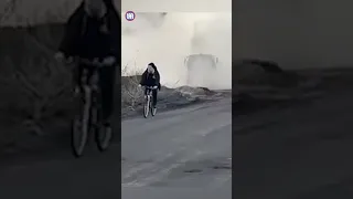 Crazy moment man in Ukraine cycles past a HIMARS launch