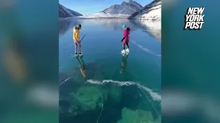 Alaskan couple skate on clear 'ice window' that formed over lake