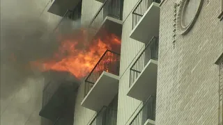 Large flames shoot out of North Side high-rise as CFD battles fire