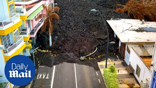 Drone footage of thick black lava swallowing La Palma landscape