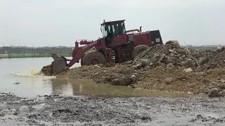 Huge lake filling for construction continuing operation by big wheel loader Dozer moving dirt