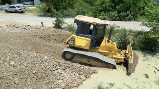 Very perfect work by bulldozer heavy equipment komatsu against the tree and land mad by DJI 4K drone