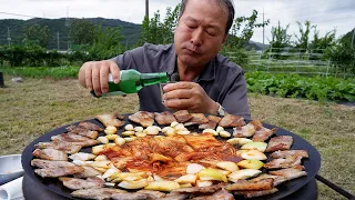 Samgyeopsal, Kimchi, onion, garlic on a cauldron lid with alcohol - Mukbang eating show