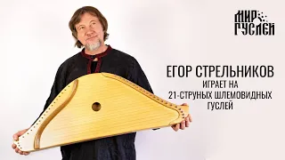 Егор Стрельников играет на 21-струнных шлемовидных гуслях.