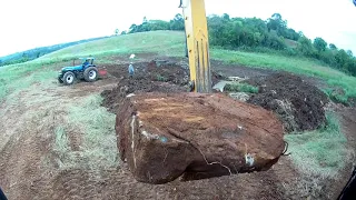 Escavadeira XCMG XE 215BR tirando pedras da lavoura e usando para dreno
