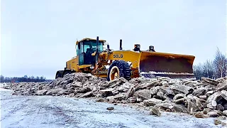 Автогрейдер борется со льдом на дороге.