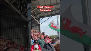 Wrexham fans celebrate beating Doncaster after the final whistle.