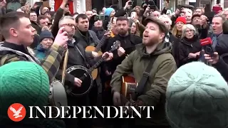 Crowds sing Shane MacGowan's hits as funeral procession travels through Dublin