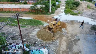 Nice job dozer pushing stone to delete the dirt with dump trucks unloading