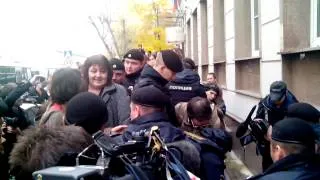 Полиция перерезает наручники, которым приковал себя участник акции