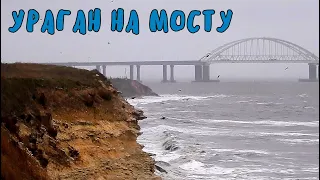 Крымский мост.На мосту и вокруг бушует ураган.Сильный ветер и дождь.Ходят машины,поезда