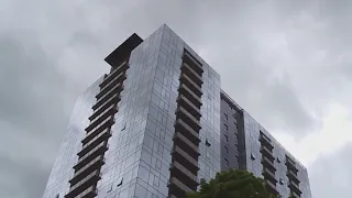 Someone is throwing cans at people, cars from a downtown high-rise in Portland