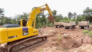 KOMATSU Pc200ce-10 is excavating hard rock called gravel for a dump truck.