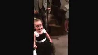 Funny flower girl stops mid aisle to say hi to dad