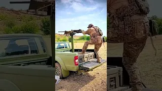 Ukrainian fighter handling a Browning M2 .50 caliber heavy machine gun mounted on a pickup truck