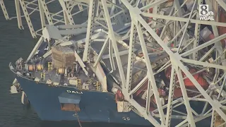 Aerial video: Chunks of collapsed bridge drape across ship’s bow, sink into water