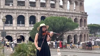 playing violin next to the Colosseum in Rome, Italy